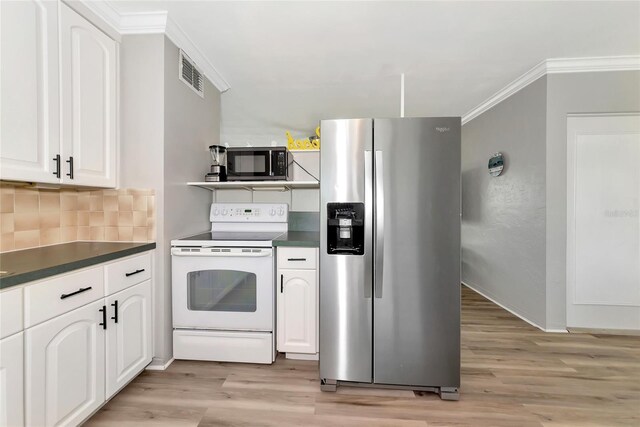 320 59th St W, Bradenton, FL 34209 - kitchen with appliances with stainless steel finishes, dark countertops, light wood-type flooring, and crown molding