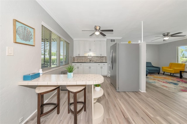 320 59th St W, Bradenton, FL 34209 - kitchen with stainless steel fridge with ice dispenser, ceiling fan, a sink, a peninsula, and ornamental molding