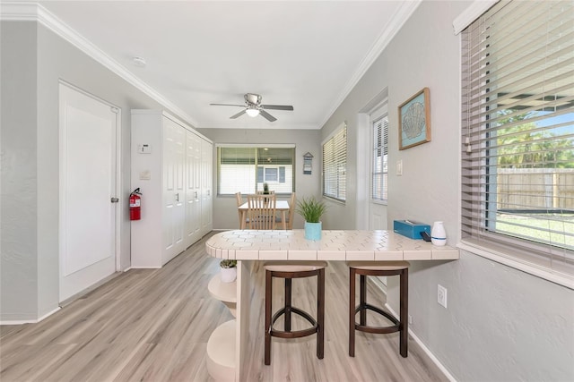 320 59th St W, Bradenton, FL 34209 - dining space featuring light wood-style floors, crown molding, ceiling fan, and baseboards