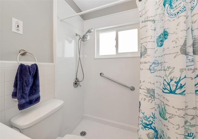 320 59th St W, Bradenton, FL 34209 - bathroom featuring a shower with shower curtain, tile walls, toilet, and a wainscoted wall