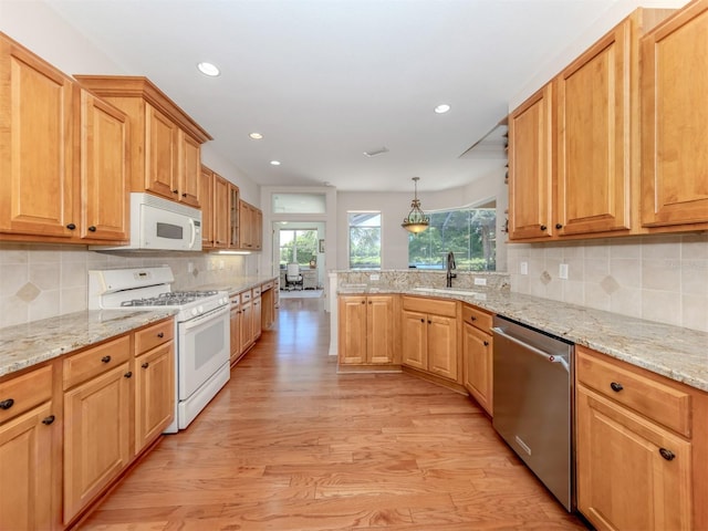 673 Crane Prairie Way, Osprey, FL 34229 - kitchen with white appliances, light wood finished floors, a peninsula, recessed lighting, and backsplash