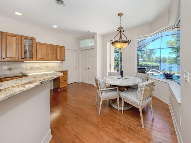 673 Crane Prairie Way, Osprey, FL 34229 - dining room featuring wood finished floors, recessed lighting, and a water view