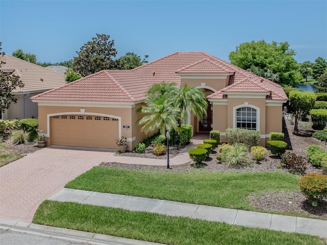 673 Crane Prairie Way, Osprey, FL 34229 - mediterranean / spanish home featuring a garage, stucco siding, a tile roof, and driveway