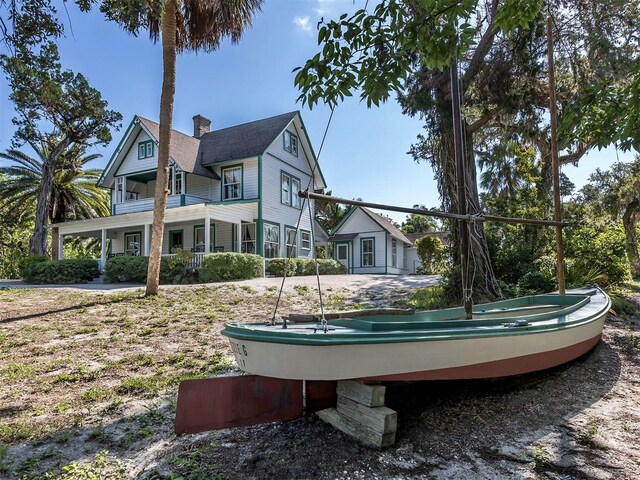 673 Crane Prairie Way, Osprey, FL 34229 - back of house with a chimney and an outdoor hot tub