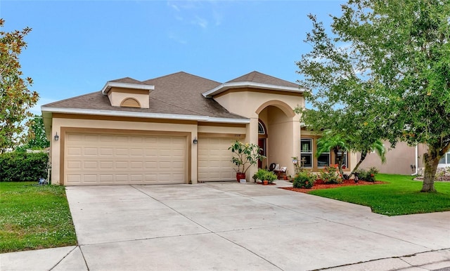 11324 77th St E, Parrish, FL 34219 - view of front facade featuring an attached garage, a front yard, stucco siding, driveway, and roof with shingles