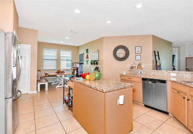 11324 77th St E, Parrish, FL 34219 - kitchen featuring stainless steel appliances, a kitchen island, light brown cabinetry, light tile patterned flooring, and recessed lighting