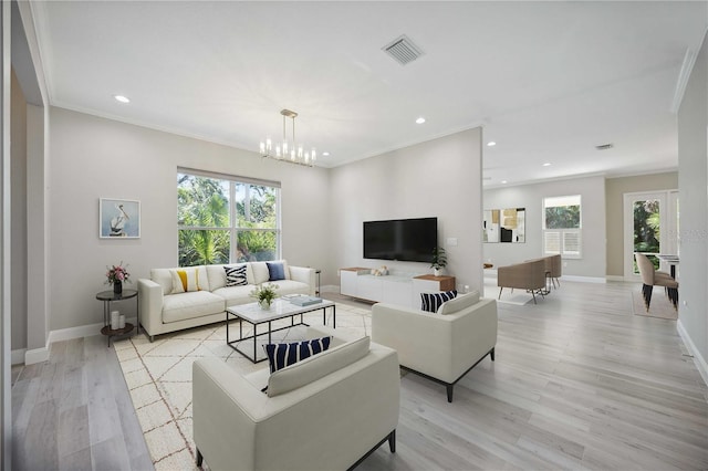 5018 Hanging Moss Ln, Sarasota, FL 34238 - living room featuring plenty of natural light, recessed lighting, light wood-style flooring, a chandelier, and ornamental molding