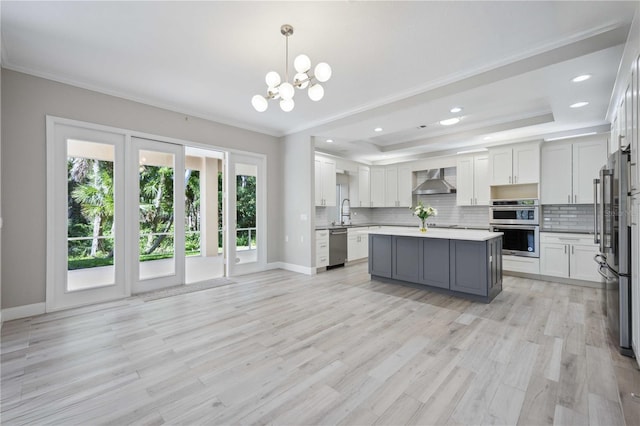 5018 Hanging Moss Ln, Sarasota, FL 34238 - kitchen featuring wall chimney range hood, ornamental molding, decorative backsplash, a chandelier, and stainless steel appliances