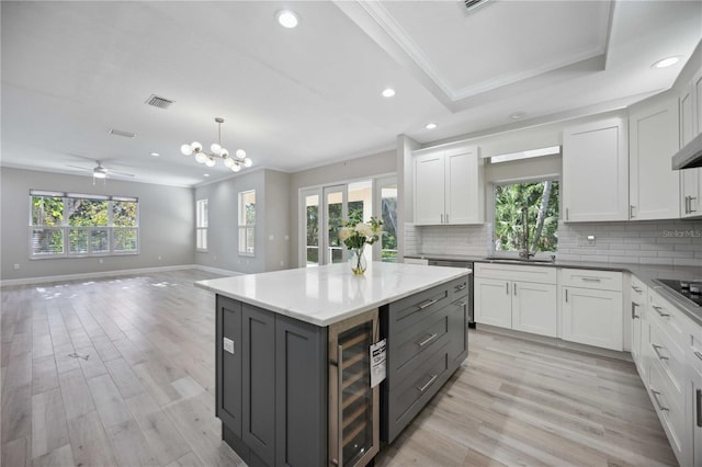 5018 Hanging Moss Ln, Sarasota, FL 34238 - kitchen with beverage cooler, crown molding, plenty of natural light, decorative backsplash, and recessed lighting
