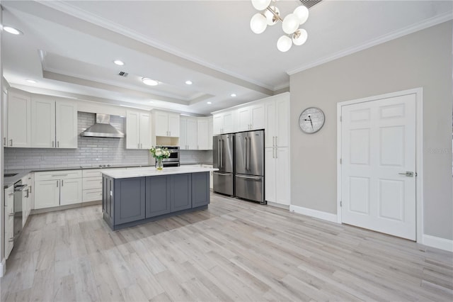 5018 Hanging Moss Ln, Sarasota, FL 34238 - kitchen featuring wall chimney exhaust hood, stainless steel appliances, ornamental molding, backsplash, and light wood-style floors