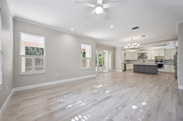 5018 Hanging Moss Ln, Sarasota, FL 34238 - unfurnished living room with crown molding, a chandelier, recessed lighting, light wood-type flooring, and ceiling fan