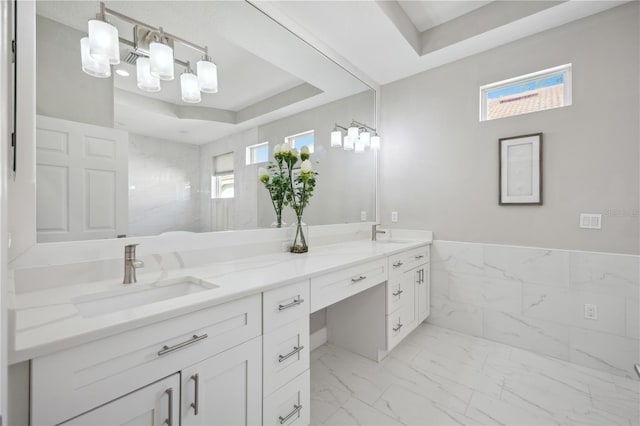 5018 Hanging Moss Ln, Sarasota, FL 34238 - bathroom featuring double vanity, marble finish floors, plenty of natural light, and a raised ceiling