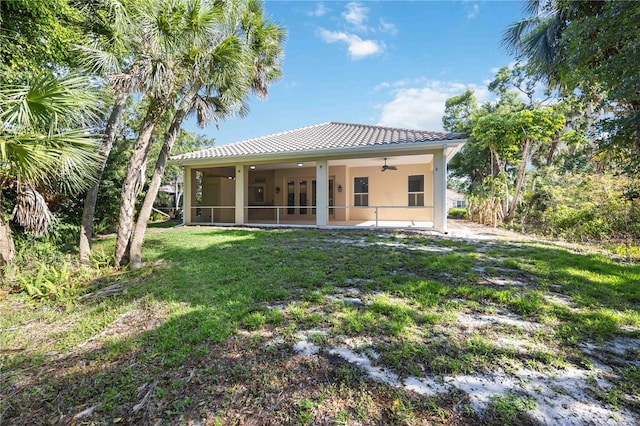 5018 Hanging Moss Ln, Sarasota, FL 34238 - rear view of property featuring ceiling fan, a lawn, a sunroom, and stucco siding