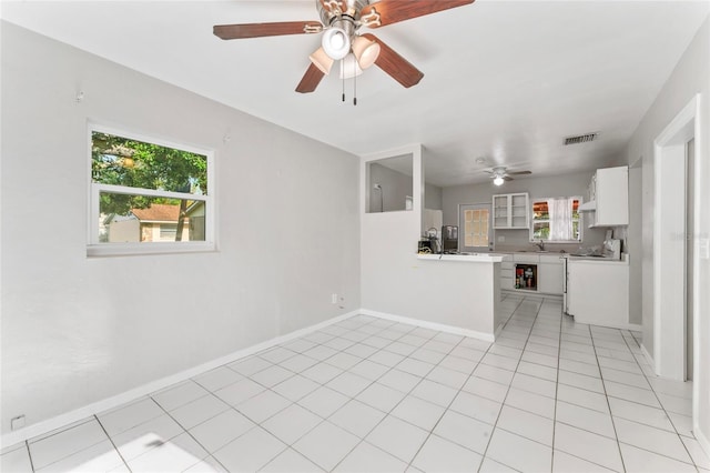 8075 48th Ave N, Saint Petersburg, FL 33709 - kitchen with a ceiling fan, white cabinets, light countertops, light tile patterned floors, and stove