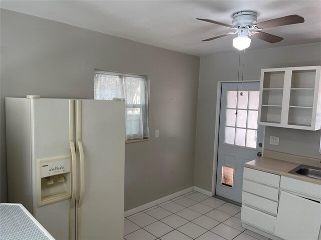 8075 48th Ave N, Saint Petersburg, FL 33709 - kitchen featuring white fridge with ice dispenser, healthy amount of natural light, white cabinetry, and light tile patterned floors