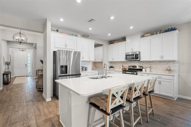 15316 Shady Palms Ln, Nokomis, FL 34275 - kitchen with stainless steel appliances, wood finished floors, a kitchen island with sink, backsplash, and recessed lighting