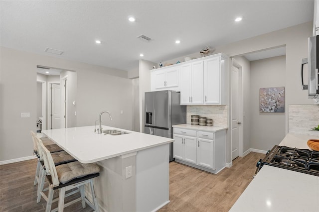 15316 Shady Palms Ln, Nokomis, FL 34275 - kitchen with stainless steel fridge, tasteful backsplash, light wood-type flooring, white cabinets, and recessed lighting