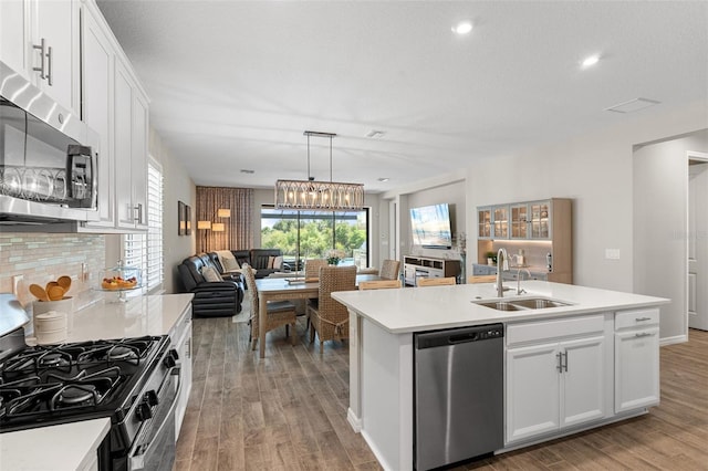 15316 Shady Palms Ln, Nokomis, FL 34275 - kitchen with stainless steel appliances, open floor plan, light wood-style floors, light countertops, and an island with sink
