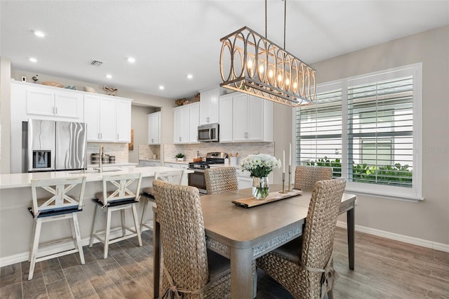 15316 Shady Palms Ln, Nokomis, FL 34275 - dining area featuring wood finished floors, recessed lighting, and a chandelier