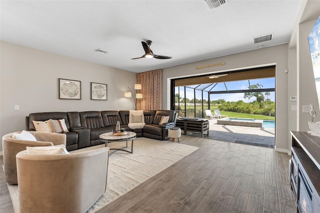 15316 Shady Palms Ln, Nokomis, FL 34275 - living area with wood finished floors, a ceiling fan, and a sunroom
