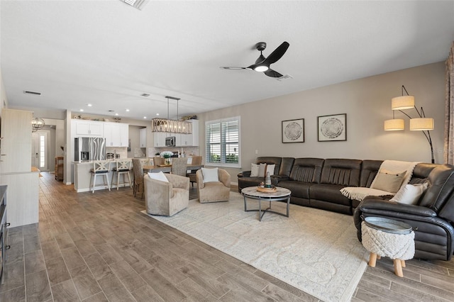 15316 Shady Palms Ln, Nokomis, FL 34275 - living area featuring a ceiling fan, wood finished floors, recessed lighting, and a chandelier