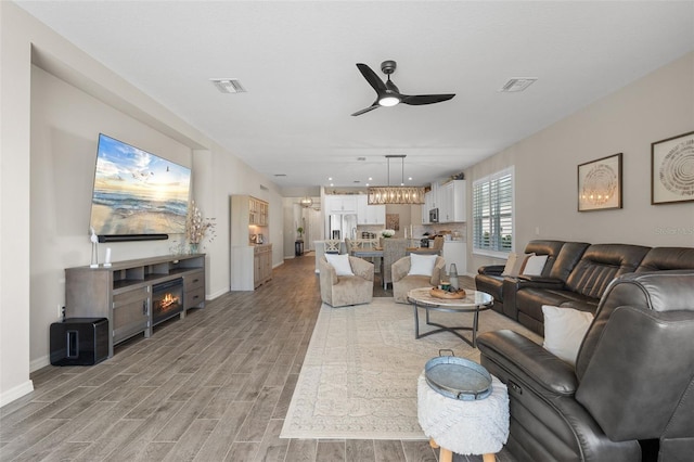 15316 Shady Palms Ln, Nokomis, FL 34275 - living area featuring ceiling fan, light wood-type flooring, and a fireplace