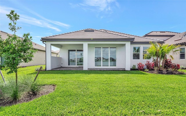 17333 Savory Mist Cir, Bradenton, FL 34211 - rear view of house featuring a lawn, stucco siding, and a tile roof
