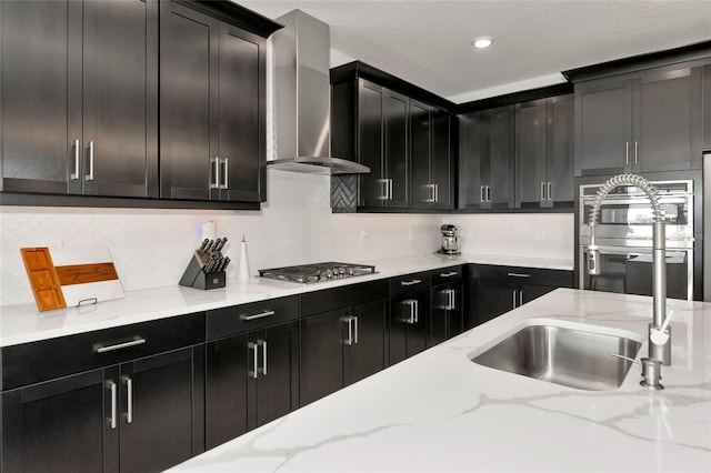17333 Savory Mist Cir, Bradenton, FL 34211 - kitchen with wall chimney exhaust hood, stainless steel appliances, dark cabinetry, a sink, and recessed lighting