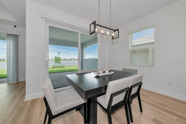 17333 Savory Mist Cir, Bradenton, FL 34211 - dining area with light wood finished floors, baseboards, and a chandelier