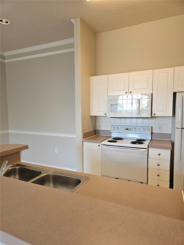 5146 Northridge Rd Unit 310, Sarasota, FL 34238 - kitchen with white appliances, crown molding, a sink, tasteful backsplash, and white cabinetry