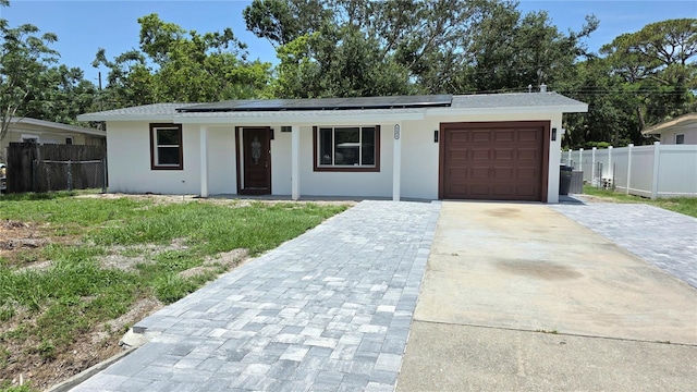 6404 8th Street Ct W, Bradenton, FL 34207 - view of front of home featuring driveway, solar panels, an attached garage, and stucco siding