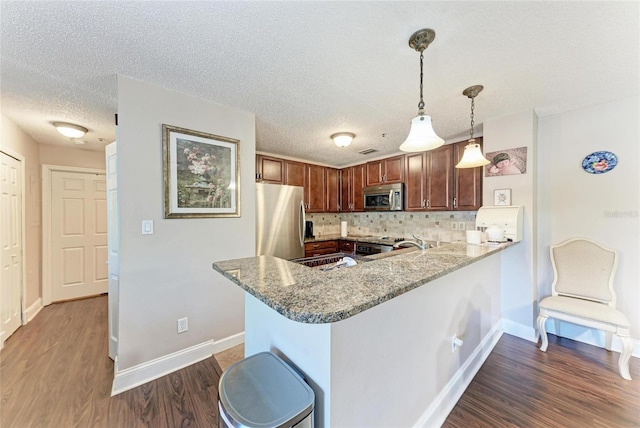 4057 Crockers Lake Blvd Unit 15, Sarasota, FL 34238 - kitchen with appliances with stainless steel finishes, dark wood-style floors, decorative backsplash, a textured ceiling, and light stone countertops