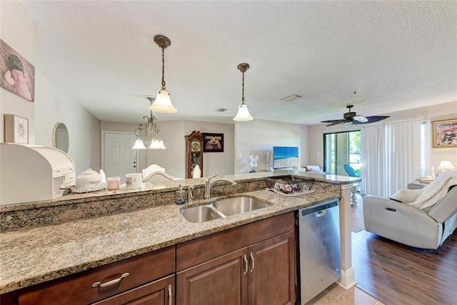 4057 Crockers Lake Blvd Unit 15, Sarasota, FL 34238 - kitchen with dishwasher, open floor plan, a textured ceiling, light stone counters, and decorative light fixtures