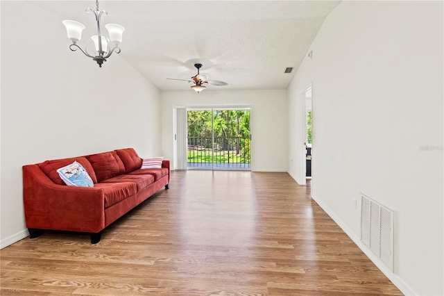 5500 Longwood Run Blvd Unit 203, Sarasota, FL 34243 - living room featuring light wood-style flooring, ceiling fan, a chandelier, and a textured ceiling