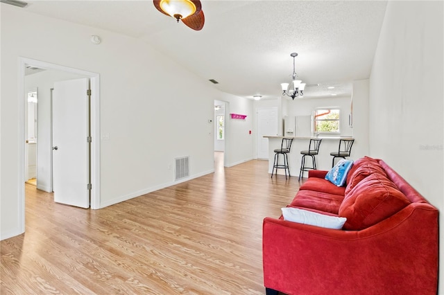5500 Longwood Run Blvd Unit 203, Sarasota, FL 34243 - living room featuring a chandelier, light wood finished floors, and lofted ceiling