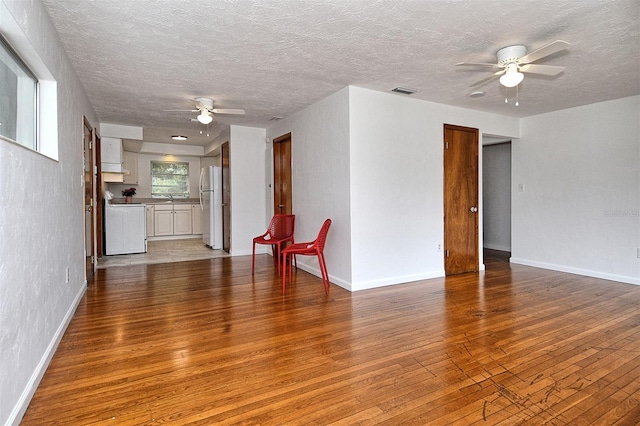 1354 22nd St, Sarasota, FL 34234 - unfurnished living room with a ceiling fan, light wood-style floors, and a textured ceiling