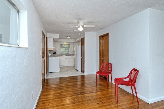 1354 22nd St, Sarasota, FL 34234 - sitting room featuring light wood-style flooring, a ceiling fan, a textured ceiling, and a textured wall