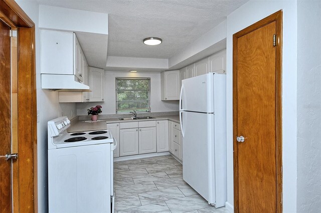 1354 22nd St, Sarasota, FL 34234 - kitchen with white appliances, light marble finish floors, under cabinet range hood, white cabinets, and a textured ceiling