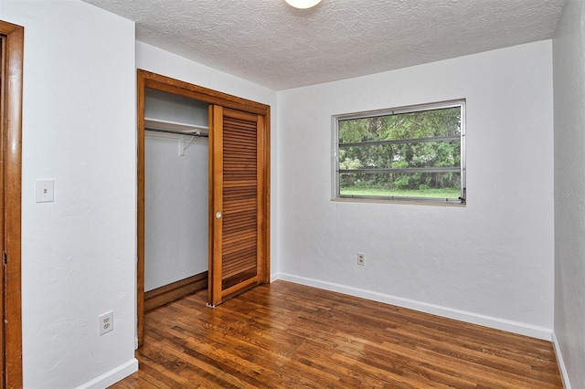 1354 22nd St, Sarasota, FL 34234 - unfurnished bedroom with dark wood-style floors, a closet, and a textured ceiling