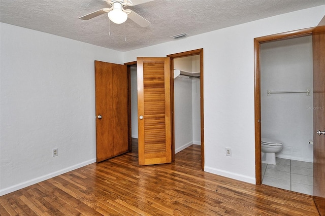 1354 22nd St, Sarasota, FL 34234 - unfurnished bedroom with wood finished floors, a textured ceiling, ensuite bathroom, and ceiling fan