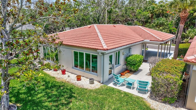 139 Vista Hermosa Cir, Sarasota, FL 34242 - rear view of property featuring a tile roof, stucco siding, and a lawn
