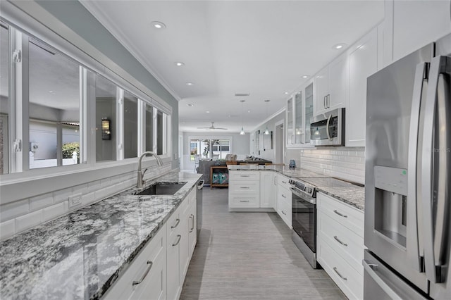 139 Vista Hermosa Cir, Sarasota, FL 34242 - kitchen with appliances with stainless steel finishes, recessed lighting, tasteful backsplash, white cabinets, and glass insert cabinets