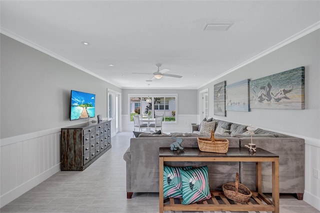 139 Vista Hermosa Cir, Sarasota, FL 34242 - living room featuring crown molding, wainscoting, a ceiling fan, a decorative wall, and light wood-style floors