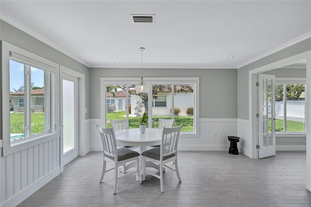 139 Vista Hermosa Cir, Sarasota, FL 34242 - dining area with wood finished floors, healthy amount of natural light, a wainscoted wall, and crown molding