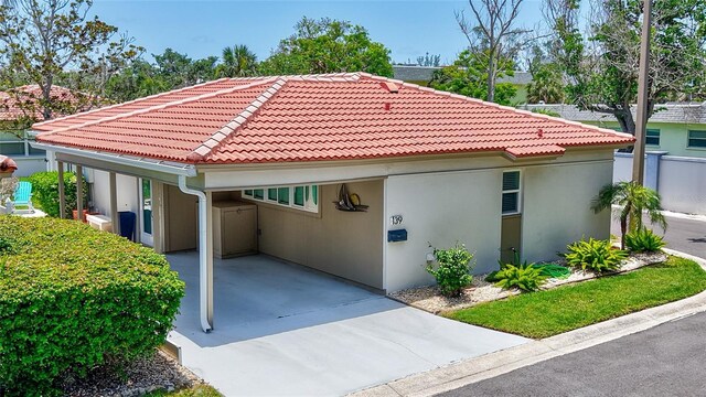 139 Vista Hermosa Cir, Sarasota, FL 34242 - view of home's exterior featuring concrete driveway, a carport, stucco siding, and a tile roof