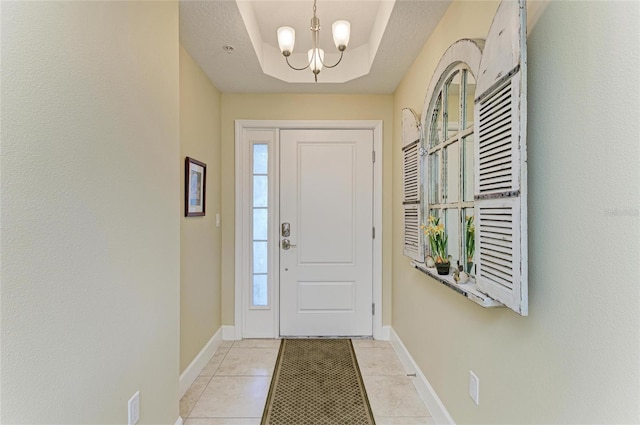 7820 34th Ave W Unit 102, Bradenton, FL 34209 - entrance foyer featuring a chandelier, plenty of natural light, light tile patterned floors, and a tray ceiling
