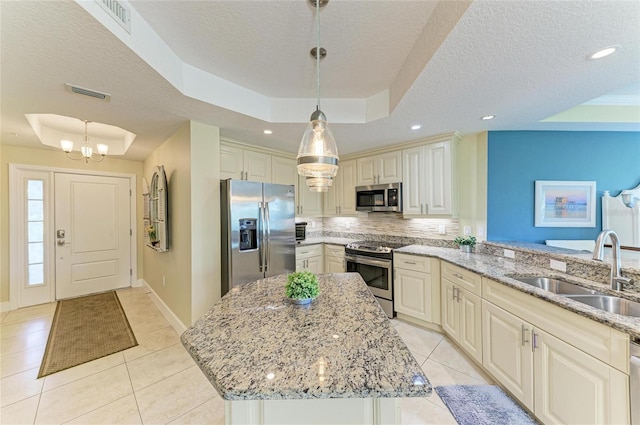 7820 34th Ave W Unit 102, Bradenton, FL 34209 - kitchen featuring stainless steel appliances, a raised ceiling, light tile patterned floors, a textured ceiling, and recessed lighting