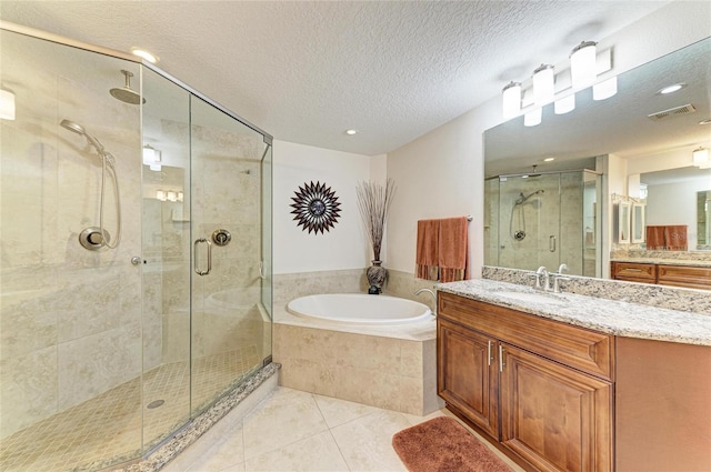 7820 34th Ave W Unit 102, Bradenton, FL 34209 - bathroom with a shower stall, a garden tub, vanity, tile patterned flooring, and a textured ceiling
