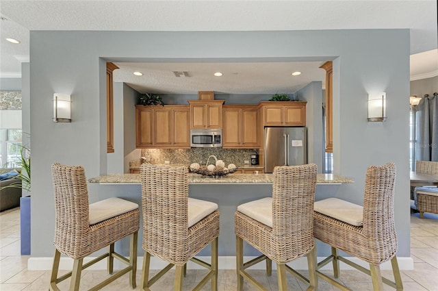7820 34th Ave W Unit 102, Bradenton, FL 34209 - kitchen featuring appliances with stainless steel finishes, decorative backsplash, a peninsula, light tile patterned flooring, and recessed lighting