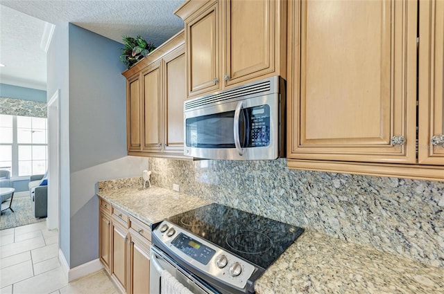 7820 34th Ave W Unit 102, Bradenton, FL 34209 - kitchen featuring stainless steel appliances, a textured ceiling, tasteful backsplash, light stone counters, and light tile patterned floors